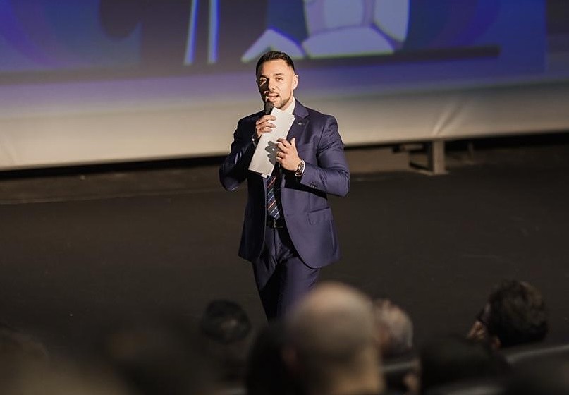 Matteo Saraconi parla sul palco a un evento del gruppo